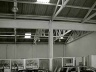 Sala adaptada de exposição e vendas. Aproveitamento de barracão preexistente, com novas divisórias separando a área de escritórios de vendas