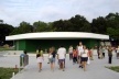 View of the amphitheatre from the main entrance. A white stripe floating against a green background<br />Foto Aristóteles Cordeiro e Mariama Ireland 