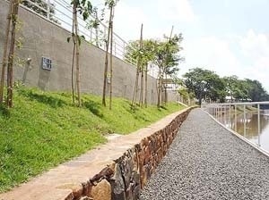 Rua do Porto, ajuste do talude da margem com arrimo em pedra basalto característica da região, delimitando o percurso da trilha e servindo como banco contínuo<br />Foto dos colaboradores do projeto