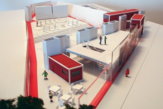 Figura 6 - Vista geral. Em primeiro plano, a praça cultural: mezanino com espaço multi-uso (leitura/ dança/computadores) e biblioteca embaixo. Ao fundo, praça esportiva com ringues de boxe e academia de ginástica. Contêineres abrigam usos específicos como