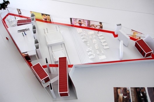 Figura 3 – Vista aérea com o viaduto: ringues de boxe deslizantes + conteineres+ Mezanino + degraus em arquibancada + pista de Cooper perimetral (em vermelho). Projeto: intervenção sob o Viaduto do Café. Arquiteto Igor Guatelli. Arquitetos Olívia Fontanet
