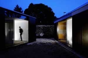 Espaço exterior entre o corpo da garagem (esq.) e o corpo principal da casa