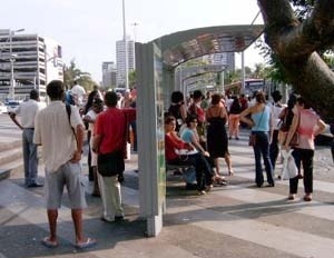 Figura 17 – Usuários se protegendo do sol na projeção da sombra fora do abrigo<br />Foto do autor